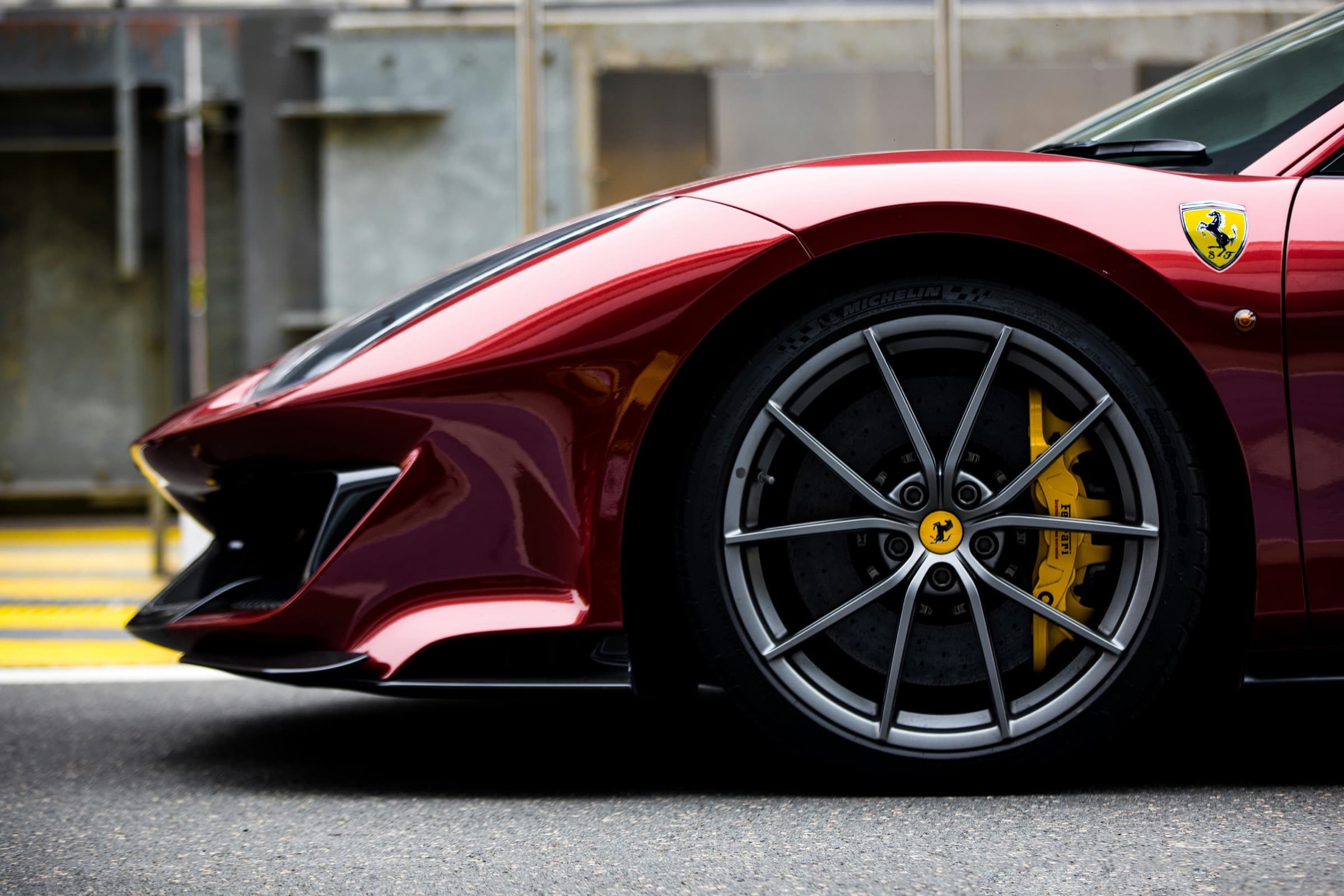 Close-up of a red Ferrari front wheel and carbon-ceramic brake on track